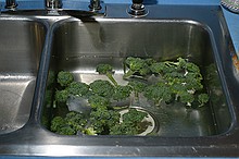 broccoli being washed in the sink