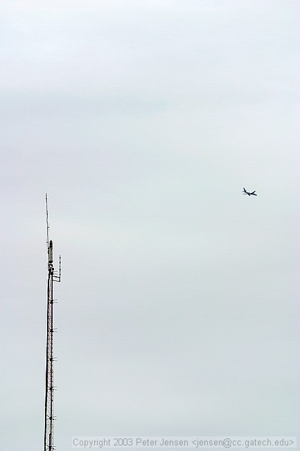 top of the WREK tower with a plane in view