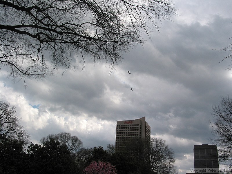 two blackhawks low over campus