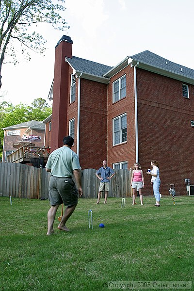 a very competitive game of croquet in the yard