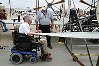 USU gentleman explaining the Wright Flyer to visitors