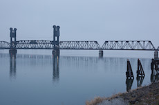 truck driving out on to the railroad bridge