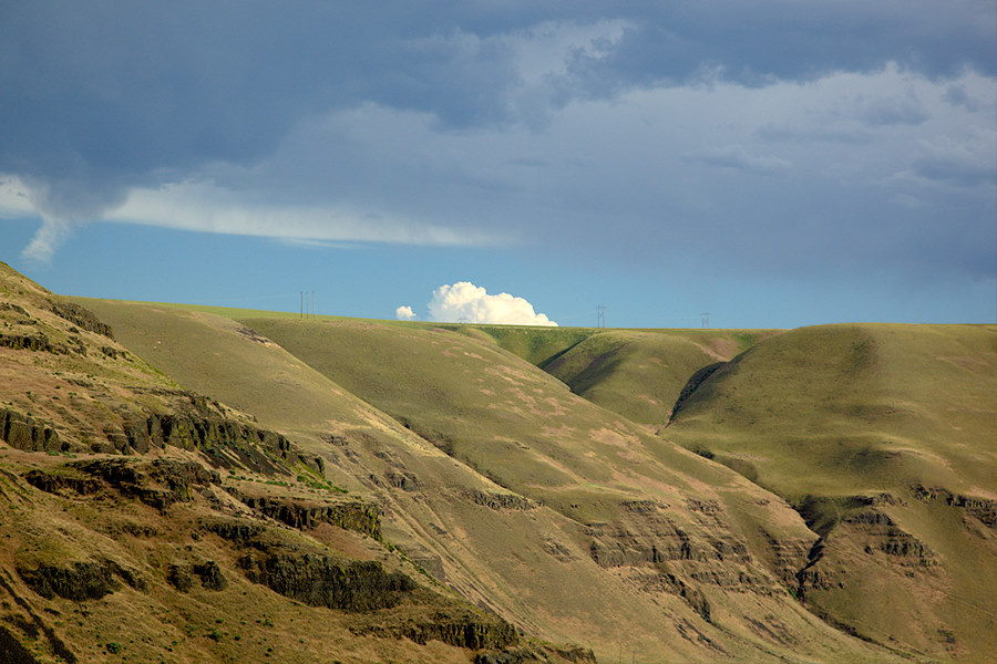 towering clouds peaking over the hills