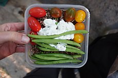 some sort of grain, ground beaf w/ peas, string peas, tomatoes, tzatziki sauce